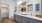 Apartment bathroom with gray cabinets, double vanity and view of spacious closet at Legacy Universal